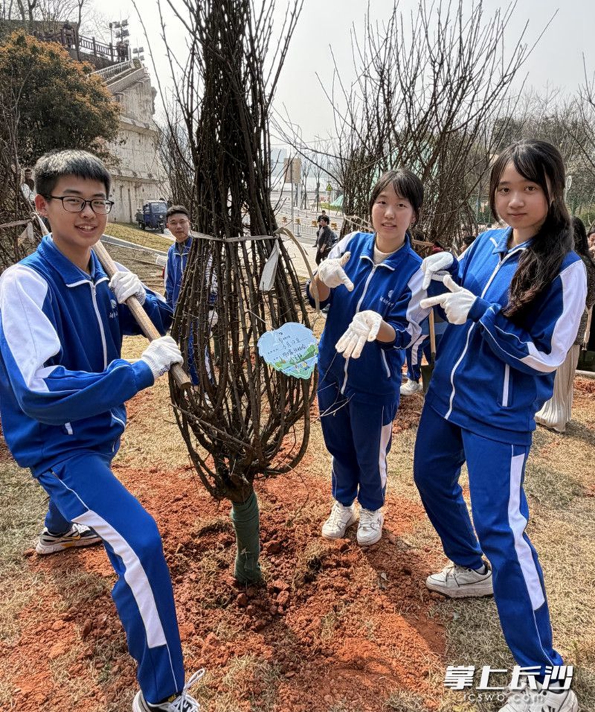 孩子们高兴地和树牌合影。 孩子们高兴地和树牌合影。
